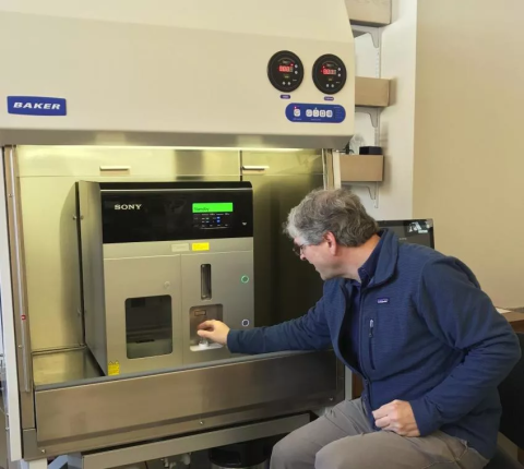 A man sitting in front of a Sony Flow Cytometer Sorter at the University Instrumentation Center at UNH