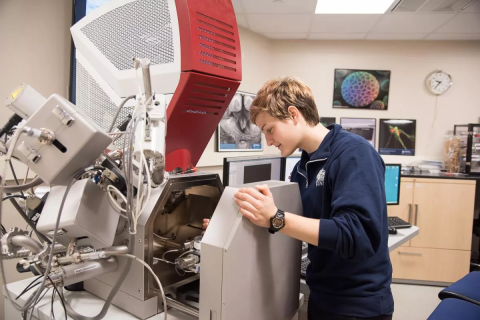 Image of a woman using the Electron Microscope, Scanning - Tescan Lyra3 GMU FIB SEM at the University Instrumentation Center at UNH